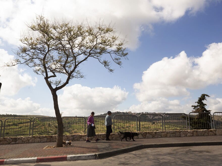 In this file photo from 2021, two women walk in the West Bank Jewish settlement of Efrat.