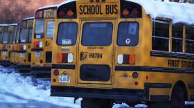 Snow covered school busses sit in a parking lot. (Nam Y. Huh/AP)