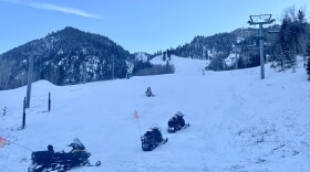 Snowmobiles line the base of Aspen Mountain, where a run of mostly machine-made snow meets mud, on Nov. 21, 2023. The ski area will open as scheduled on Nov. 23, but with limited terrain.