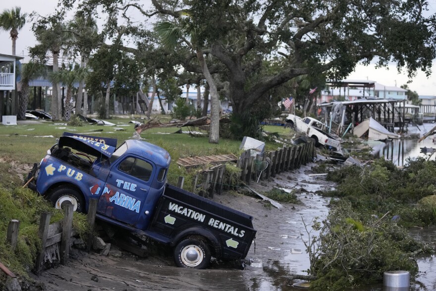 Pick up trucks and debris lie strewn in a canal in Horseshoe Beach, Fla., after the passage of Hurricane Idalia, Wednesday, Aug. 30, 2023.