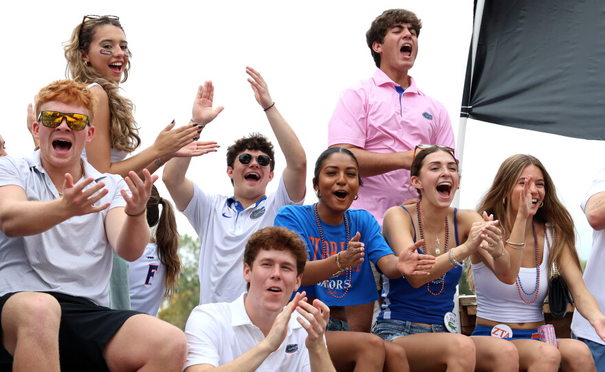 Greek life paraders cheer from their float during the University of Florida Homecoming parade in Gainesville Friday, Oct. 9, 2026. (Isabel Kraby/WUFT News)