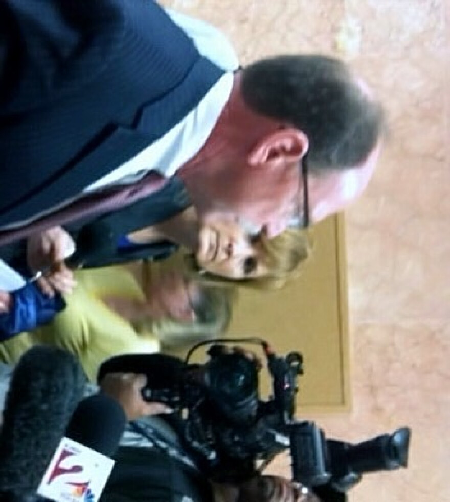 District Attorney Tim Harris discusses the case with reporters in the courthouse hall way.