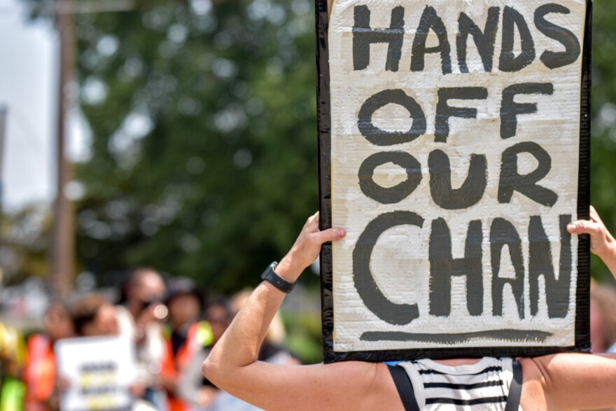 A protester outside U.S. Immigration and Customs Enforcement’s field office in Warwick, Rhode Island, on July 22, 2026. Demonstrators had hoped to keep ICE agents from detaining a Cambodian man who has lived in the state since he was an infant. Credit: Christopher Shea/Rhode Island Current