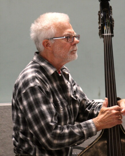 A man stands with his upright bass.