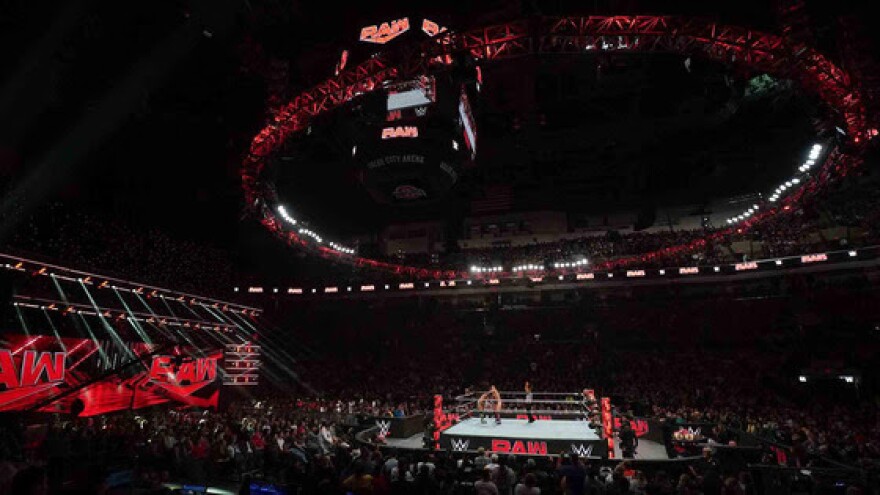 an arena lit up with red lights for WWE