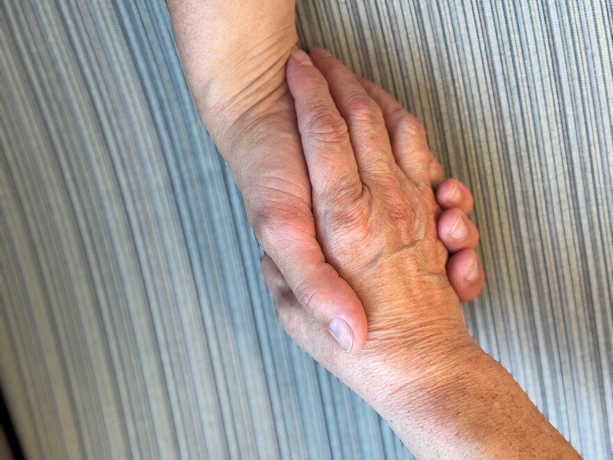 Two hands are clasped together.