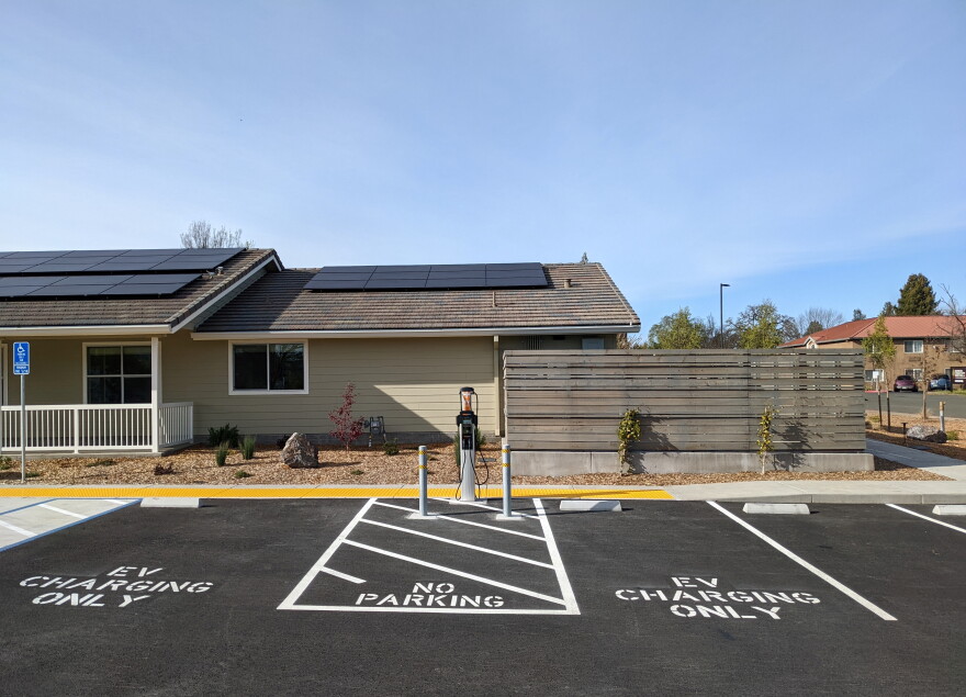 A building and a parking lot with EV charging station spaces.