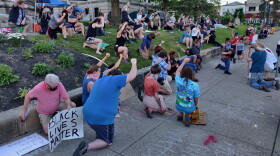 Demonstrators kneel in downtown Bloomington.