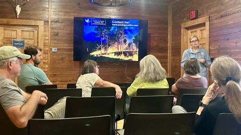 Fire ecologist Raelene Crandall explains how prescribed burns are shaping a healthier, more resilient Florida landscape to audience members gathered at the Hogtown Creek Headwater Nature Center on Sunday, Oct. 5, 2025. (Ann Rodgers/WUFT News)