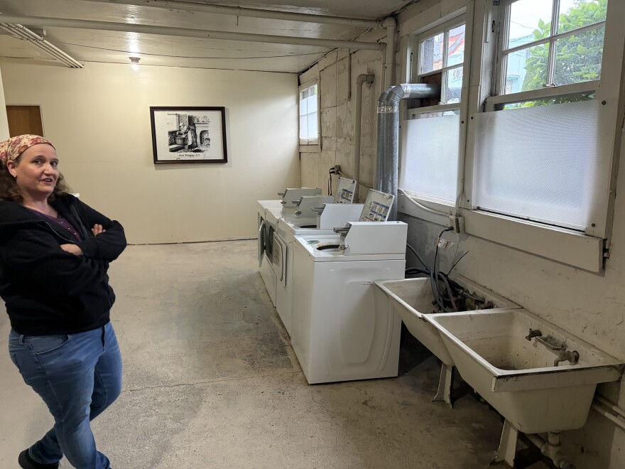A woman standing in a laudry room.