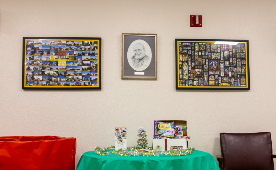 A giving table positioned under a picture of stained glass murals in other churches as well as the San Angelo Diocese, photo by Alexander Brown.