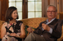 A man and a woman sitting on a gilded couch
