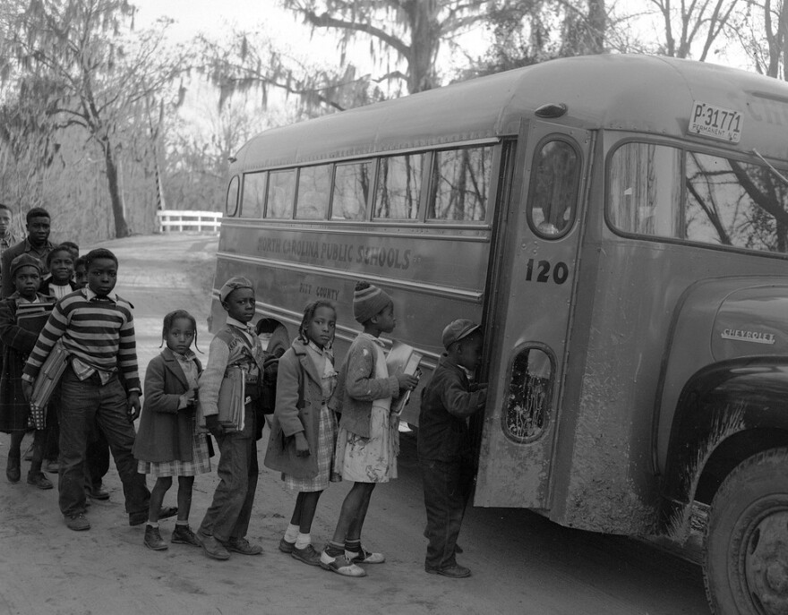 Photo of African American students getting on a school bus in Grimesland, North Carolina in the 1950s