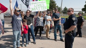 People gather at the National Interagency Fire Center to protest President Joe Biden’s visit to Boise on Sept. 13, 2021. Many brought signs to protest vaccine regulations proposed by the Biden administration to combat the spread of the coronavirus. (Jim Max/For the Idaho Capital Sun)