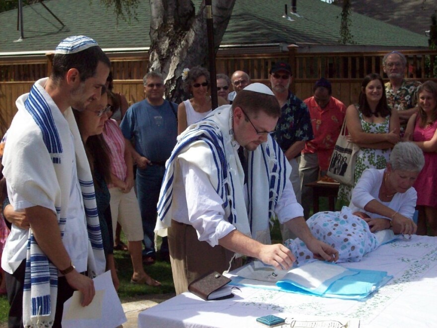 Sociologists Helen Kim and Noah Leavitt look on during their son Ari's bris. They've worked together to research how kids with mixed Asian-American and Jewish heritage think about faith.