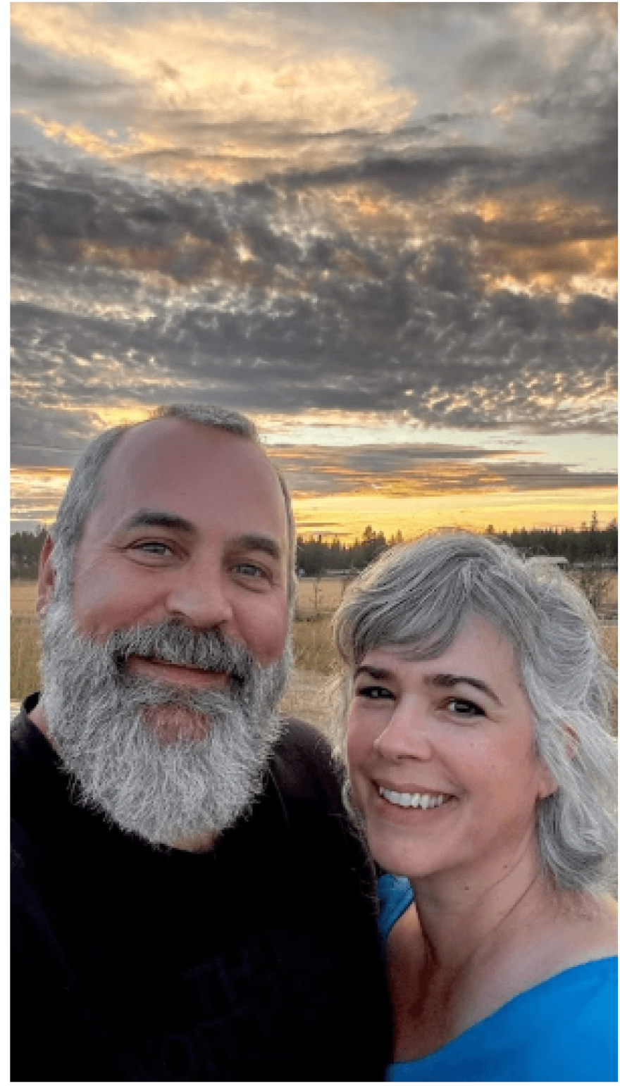 A gray-bearded man and gray-haired woman at sunset.