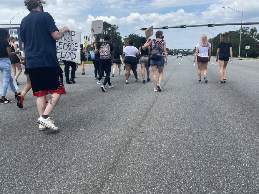 People march on Tallahassee’s north side. The group went all the way from midtown to here, up Thomasville Road, crossing under I-10. One of the busiest intersections in town in the afternoons came to a standstill as they passed