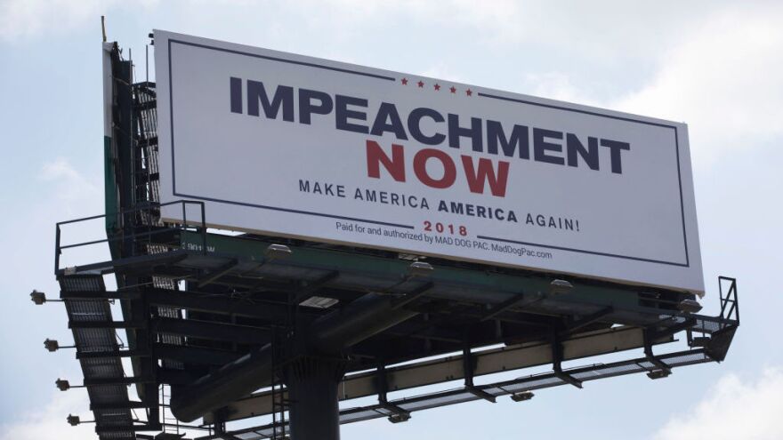 This billboard calling for President Trump's impeachment is placed along a street leading to his Mar-a-Lago resort in West Palm Beach, Fla.