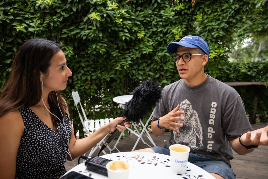 A woman holds a microphone in front of a man during an interview.