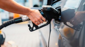 Closeup of woman pumping gasoline fuel in car at gas station. Petrol or gasoline being pumped into a motor. Transport concept