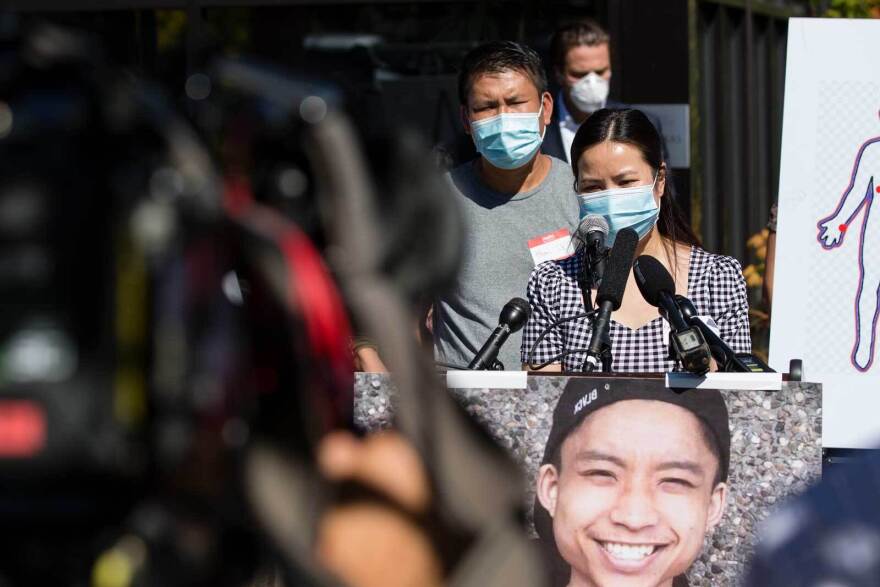 Xuyen Le, Tommy Le's aunt, speaks while Sunny Le, Tommy's father, listens in the background during a news conference Sept. 2, 2020, at the Asian Counseling and Referral Service in South Seattle. 