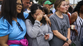 Adriana Rosales, center, wipes her face from tears during a candlelight vigil for the victims of Saturday’s shooting Sunday, May 7, 2023, at Allen Premium Outlets in Allen.