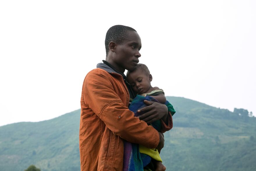 A Congolese man holds his child after he crossed the border from the Democratic Republic of Congo (DRC) to be refugees at Nteko village in western Uganda on January 24, 2018. Since Last December, Congolese people, about 300 people per day, have been fleeing from the Mai Mai militias attacks in the Kivu region of the eastern part of DRC to this border area.