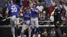 Texas Rangers' Josh Jung and Nathaniel Lowe (30) celebrates after scoring on a single by Jonah Heim during the ninth inning in Game 5 of the baseball World Series against the Arizona Diamondbacks Wednesday, Nov. 1, 2023, in Phoenix.