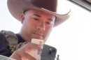 An unidentified Immigration and Customs Enforcement officer examines the driver's license of Dodge City, Kansas, resident Guadalupe Navarrete on Sept. 23, 2026. Navarrete was driving with her father Frank Duran. They were not detained.