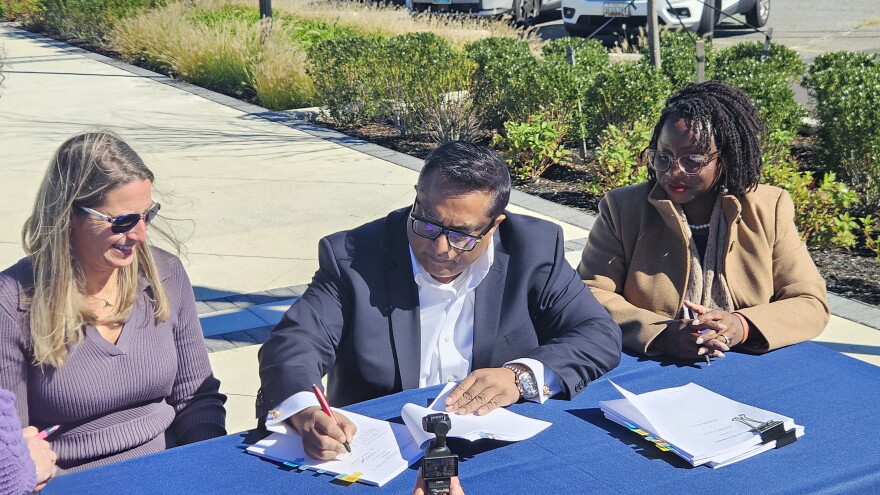 CWDI President Angie Hengst, Pinnacle Hospitality Group President Tauhid Islam and Cambridge Mayor Lajan Cephas Bey sign the Cambridge Harbor hotel agreement
