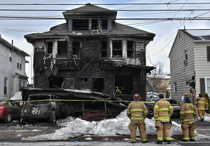Firefighters from the Kingston Forty Fort Fire Department observe the scene of a fatal fire on N. Welles Street in Kingston.