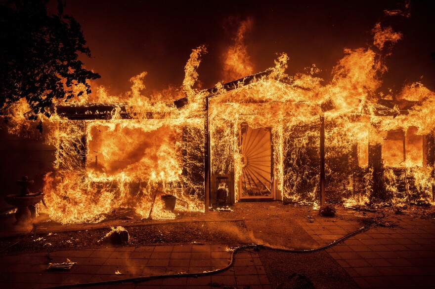 Flames consume a home on Triangle Road as the Oak Fire burns in Mariposa County, Calif., on Saturday.