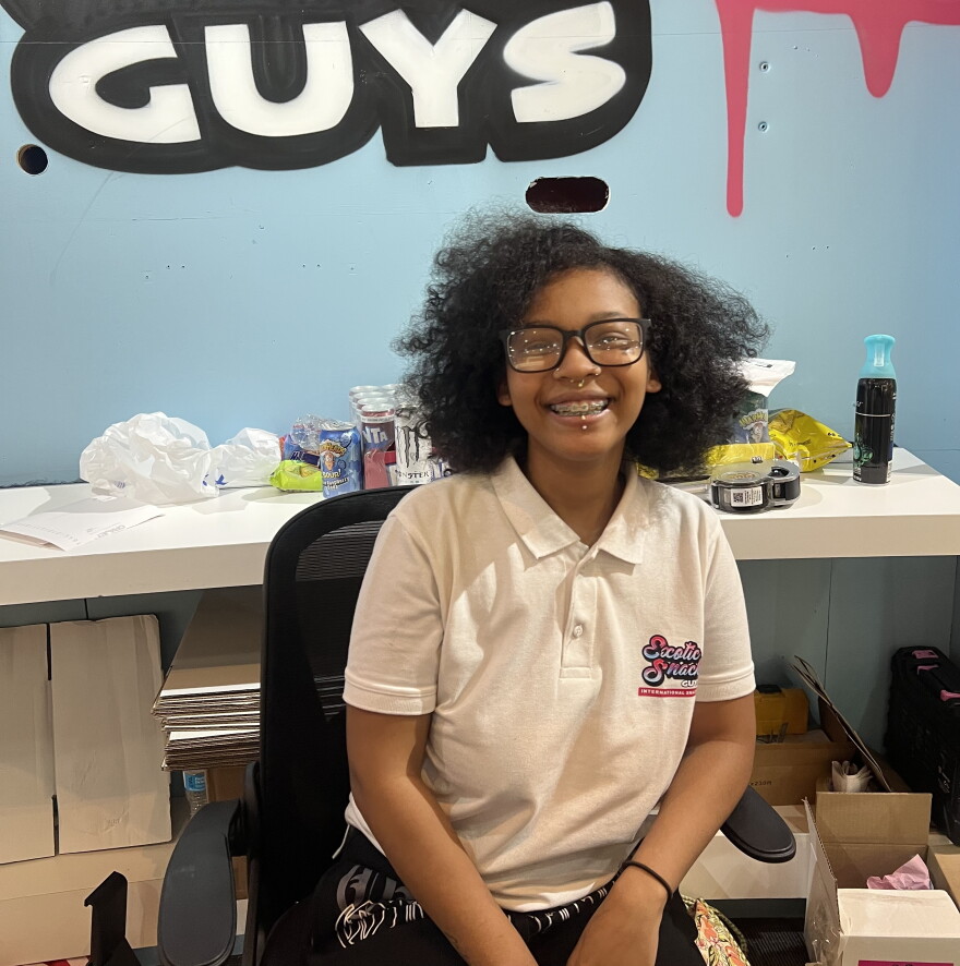 Janiya Mercado sits in her workplace, Exotic Snack Guys, in the Connecticut Post Mall in Milford.