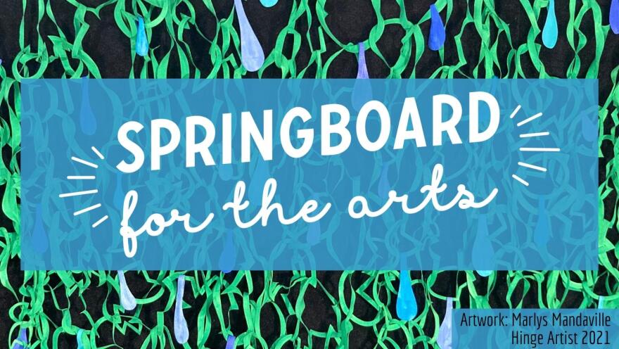 Signage reading "Springboard for the Arts" in white cursive over a transparent blue field and green and black background