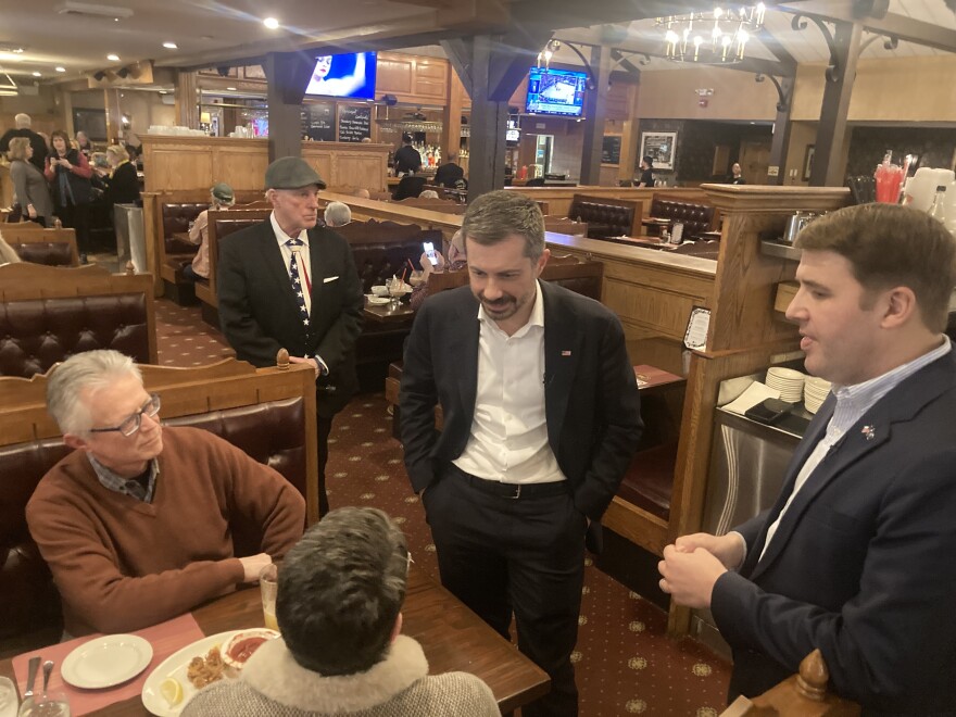Former Transportation Secretary Pete Buttigieg and U.S. Senate candidate Chris Pappas speak with potential voters in the dining room of the Puritan Backroom Restaurant in Manchester on Feb. 19, 2026.