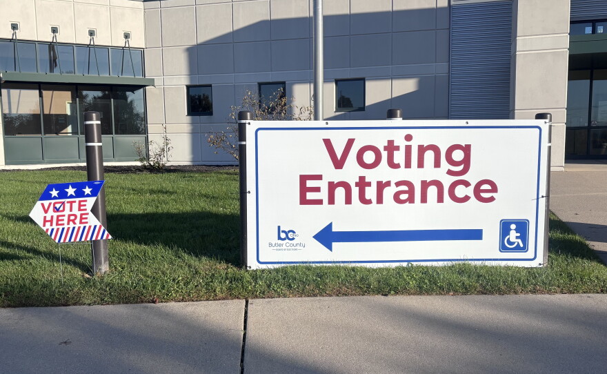 A big white sign with a red arrow and letters reads: "Voting Entrance."