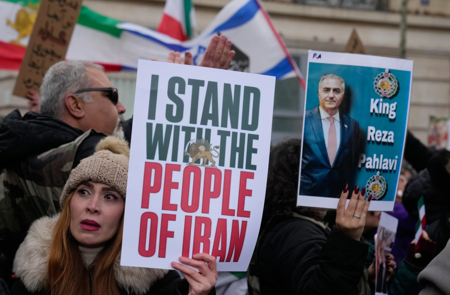Protesters hold placards during a rally in support of the nationwide mass demonstrations in Iran against the government in Paris, Sunday, Jan. 11, 2026.