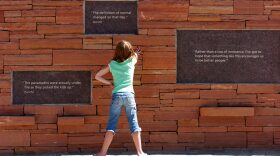 A young child reads the plaques at the Columbine Memorial near Rebel Hill and Columbine High School in Littleton, Colorado.