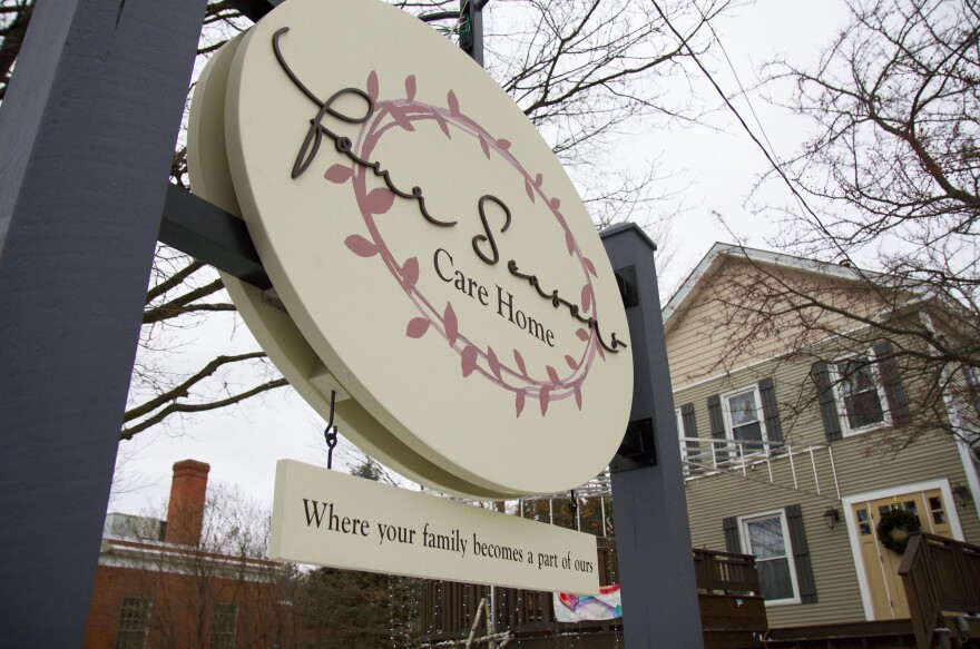 A sign reafing four seasons care home in front of a house