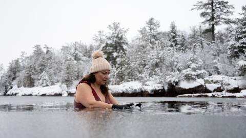 Vermont resident Tanya Talamante pauses in the icy water on Jan. 20, 2023, at Oakledge Park and Beach in Burlington, VT. (Raquel C. Zaldívar/New England News Collaborative)