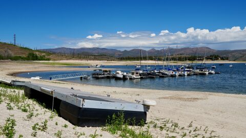 Very low water at Lake Granby shows an extended dock to get over the dirt to the boats.
