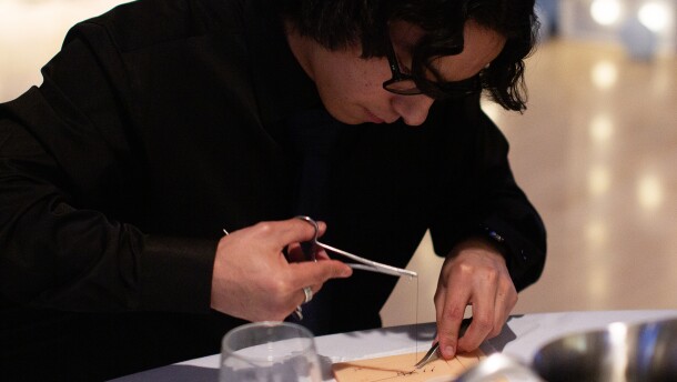 Samm Hoptowit, a Running Start student, bends over a suturing practice skin as he threads a needle through to make stiches on Monday, April 13 at the Pacific Northwest Pre-Health Spring Symposium at Washington State University. Hoptowit, who is Native American, says he's interested in going into general surgery and working in a tribal community in the future.