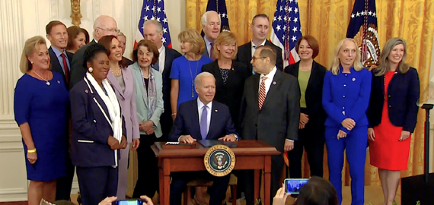 Sen. Joni Ernst, a survivor herself, stands with President Joe Biden when he signed the VOCA Fix Act into law last week. The law redirects more funding into the Crime Victims Fund.