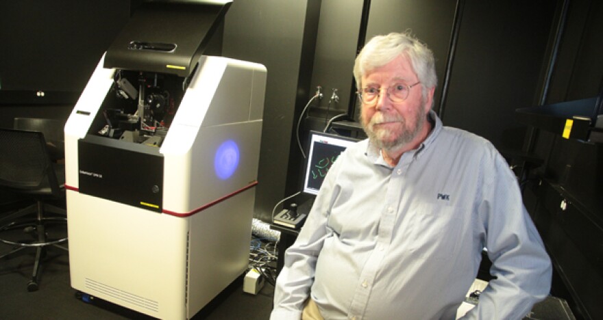 Paul Kincade, research vice president at the Oklahoma Medical Research Foundation, sits next to a new laser microscope in Oklahoma City.