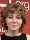 A young woman poses for a photo in front of a red wall