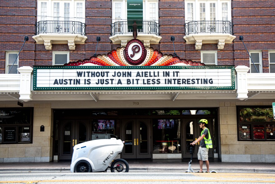 The marquee at the Paramount Theatre says: "Without John Aielli in it Austin is just a bit less interesting."