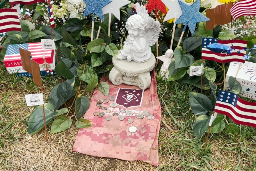 Marine Lance Corporal Dylan Merola's mother decorates his grave with flowers and flags, while his Marine colleagues leave coins. Dimes mean they served with Merolia. Quarters mean they were with him in Kabul, Afghanistan, where he was killed by a suicide bomber.