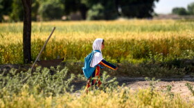 An Afghan girl walks towards her school along a field on the outskirts of Mazar-i-Sharif. (Farshad Usyan/AFP via Getty Images)