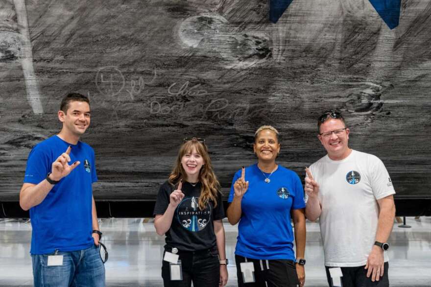 The crew of Inspiration4 signs the soot in the Falcon 9 rocket booster that will launch them into space. Photo: Inspiration4 / John Kraus