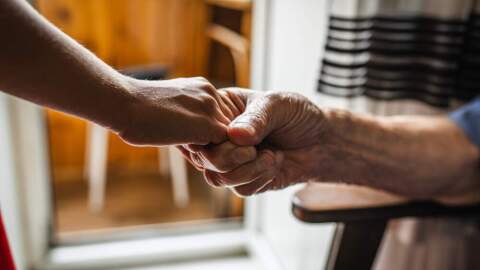 Two people hold hands. (Olga Rolenko/AP)